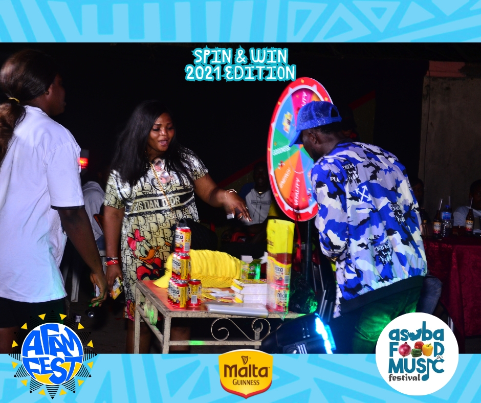 A crowd gathers around the Spin & Win booth, eagerly watching a contestant take their turn.