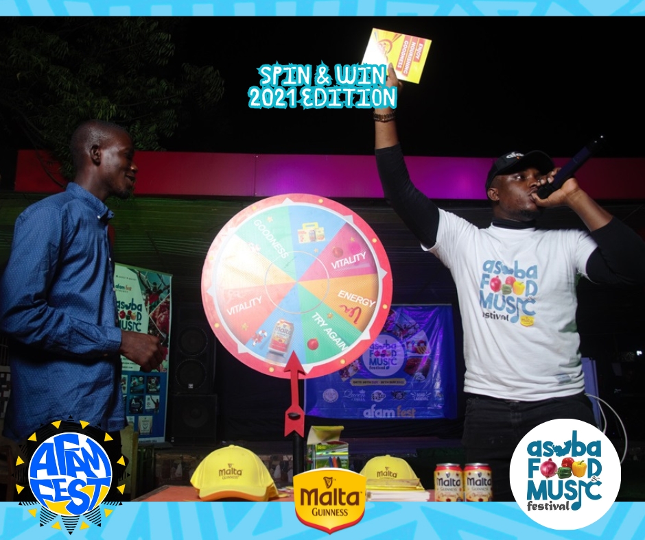 A contestant spinning the wheel while an event host announces the prize at AFAM FEST. Description: The Spin & Win Booth is always packed with festival-goers hoping to land on amazing rewards! Don’t miss your turn at AFAM FEST 2025.